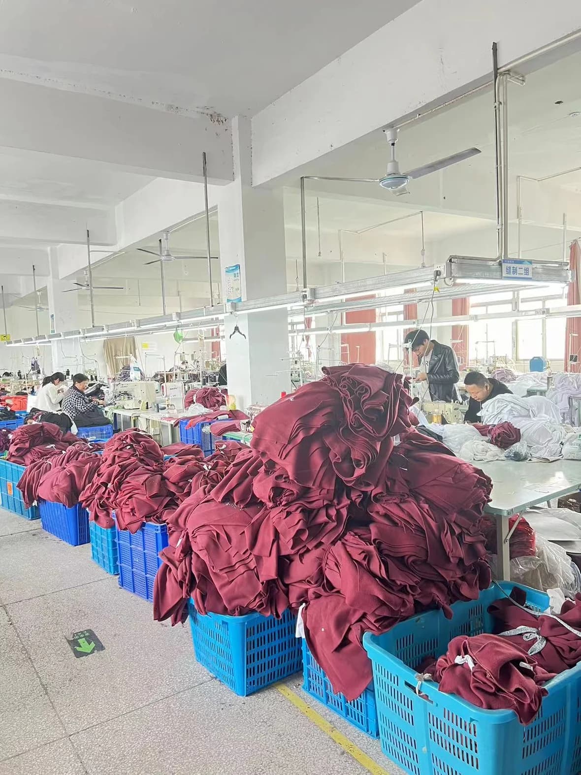Production floor with garments organized in quantity for finishing and workflow control.