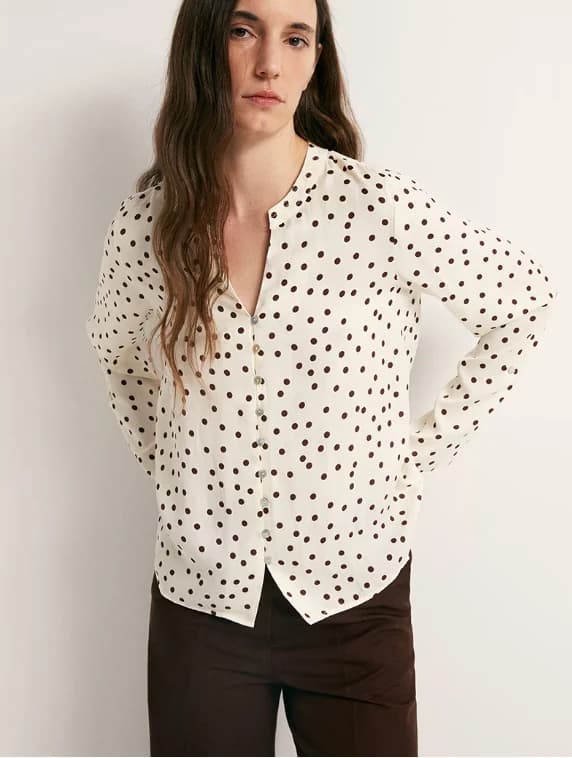 Cream printed woven blouse with a clean button-front silhouette.