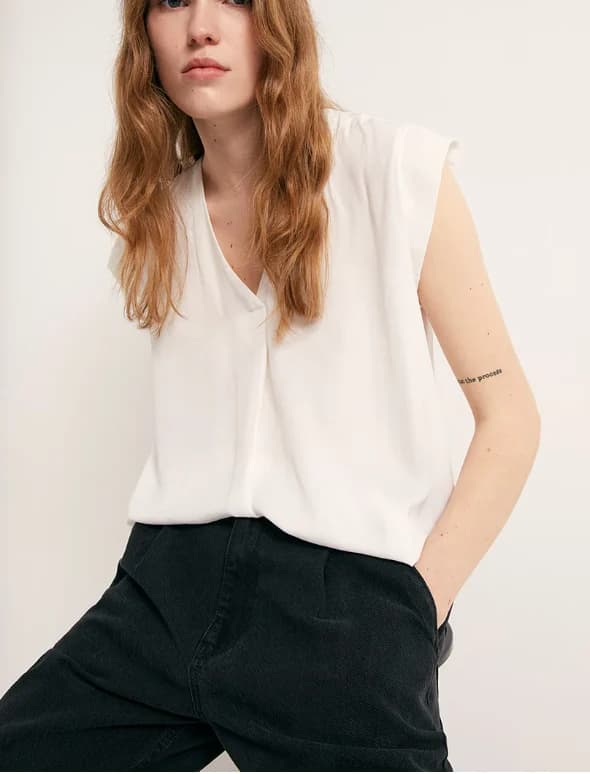 Ivory sleeveless woven top with clean neckline and soft handfeel.